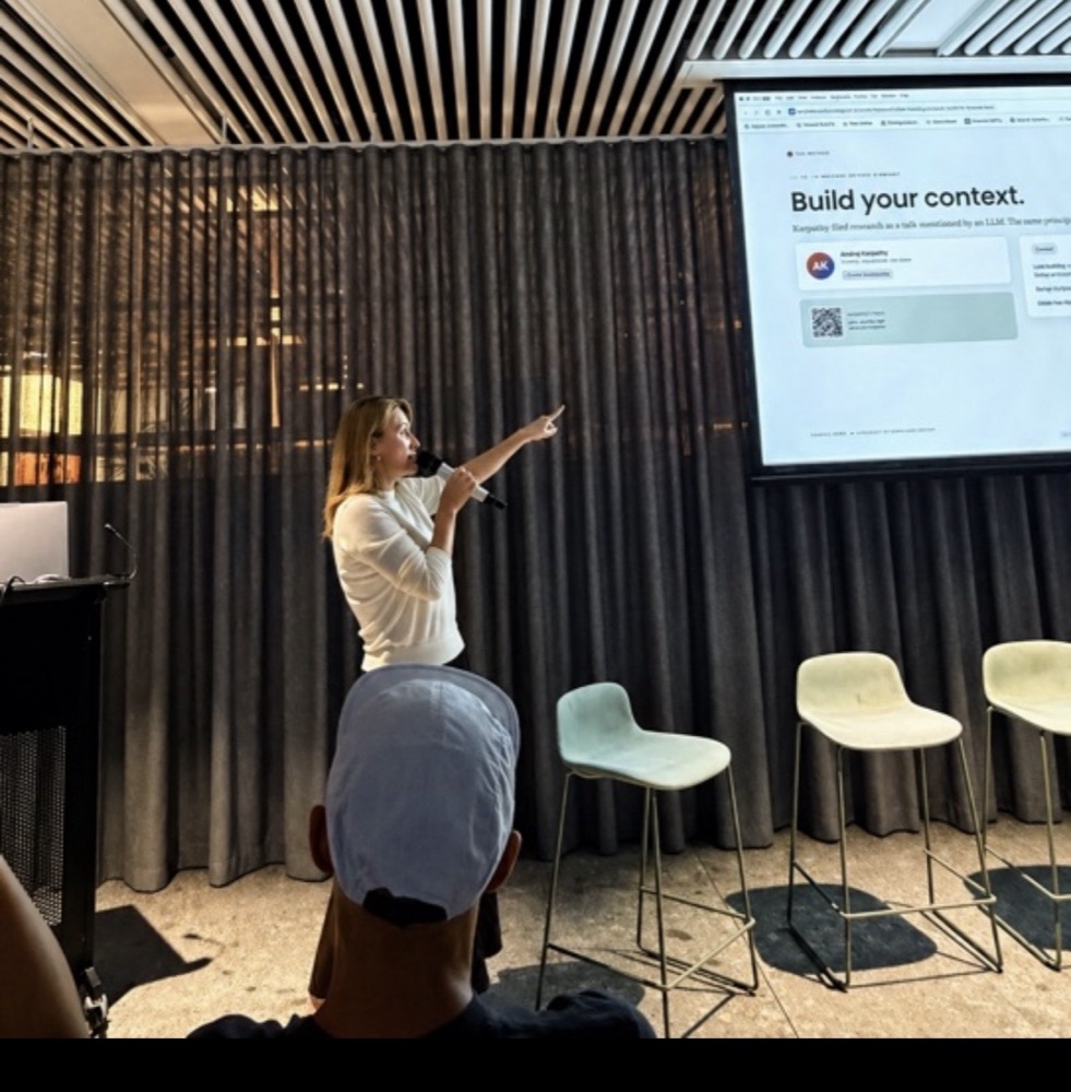 Marina Ritchie speaking on stage beside a slide reading Build your context